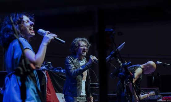 Una foto a colori, in formato orizzontale, che ritrae, da sinistra a destra, Paola Rovai, Marco Rovelli e Paolo Monti mentre si esibiscono in concerto.