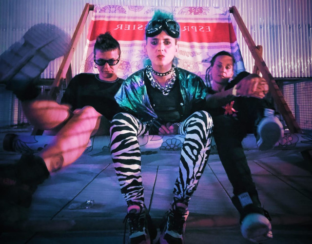 Una foto a colori che ritrae Mariana Mona Oliboni, Marzia Stano e Poppy Pellegrini sedute su una grande sdraio.